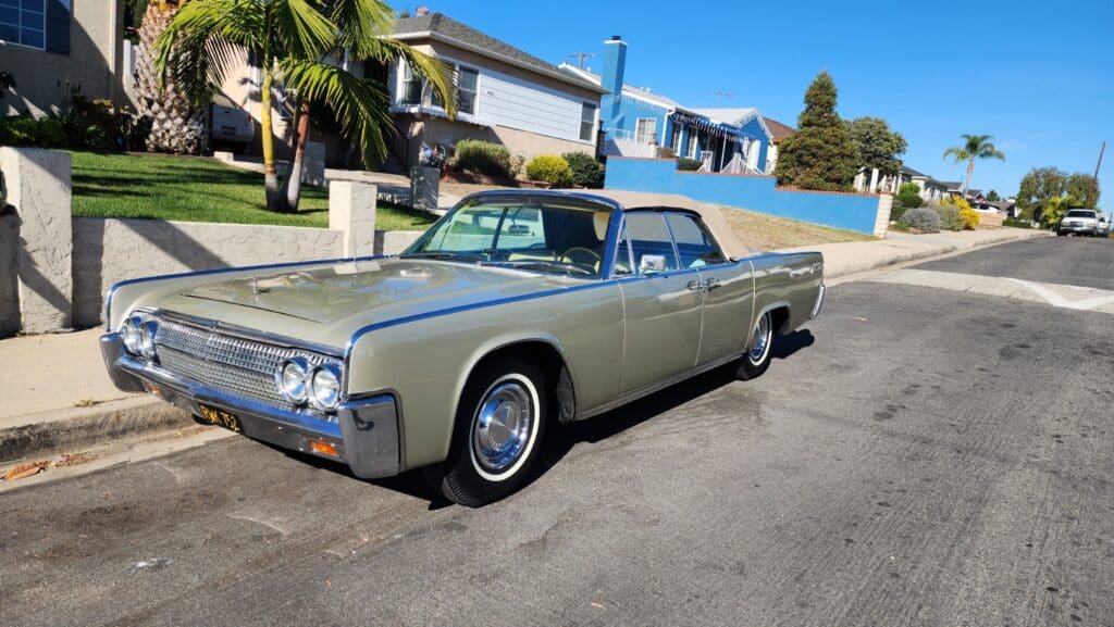 Classic vintage car parked on a sunny suburban street.