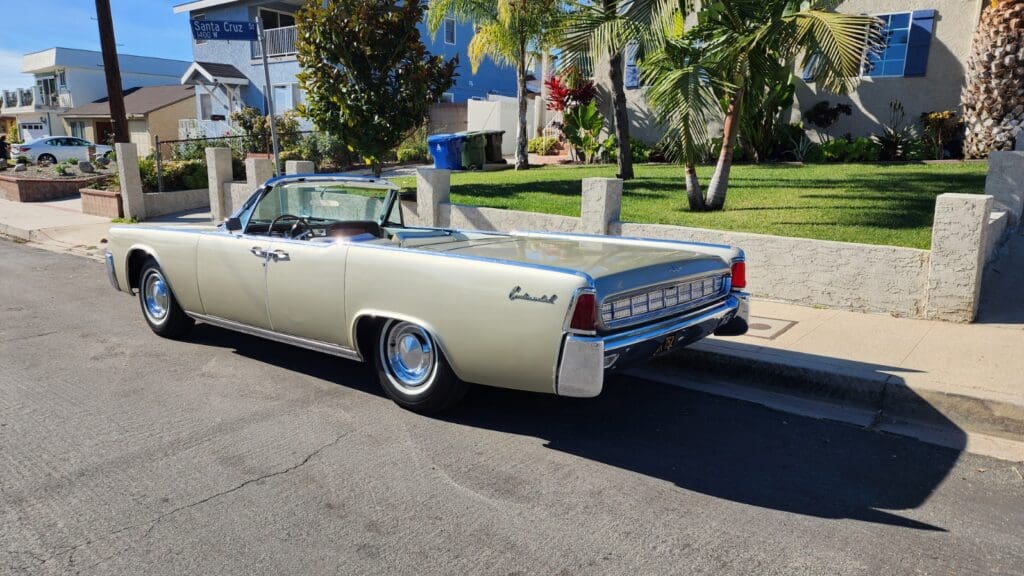 Classic convertible car parked on a sunny suburban street.