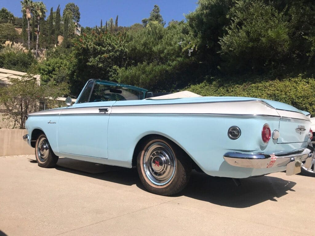 Light blue classic convertible car parked on a sunny day.