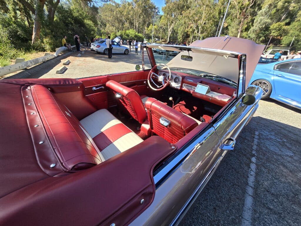 Classic convertible car with red interior and vintage dashboard.