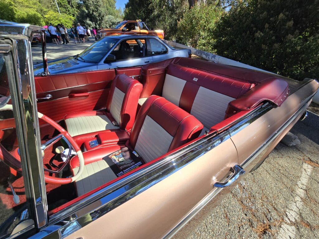 Interior of a vintage convertible car with red and white seats.