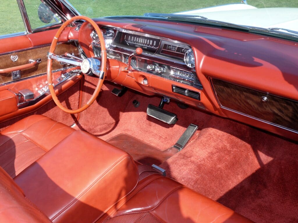 Classic car interior with red leather seats and vintage dashboard.