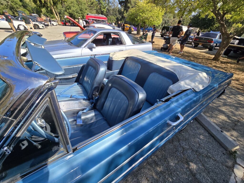 Blue vintage convertible car with detailed interior at a car show.