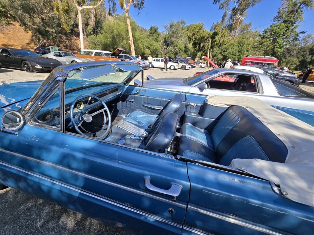 Classic blue convertible car parked outdoors on a sunny day.