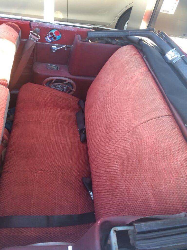 Vintage red fabric car seats with a classic design.