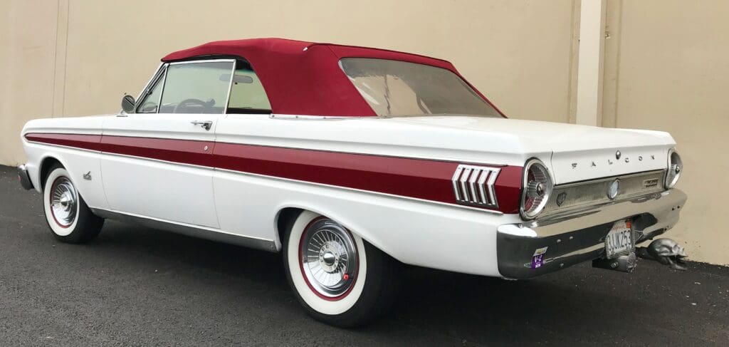 Classic white convertible car with a red soft top and vintage design.