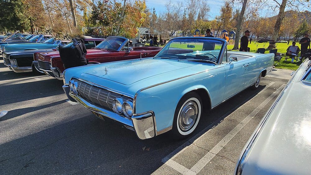 Classic light blue convertible car parked outdoors on a sunny day.