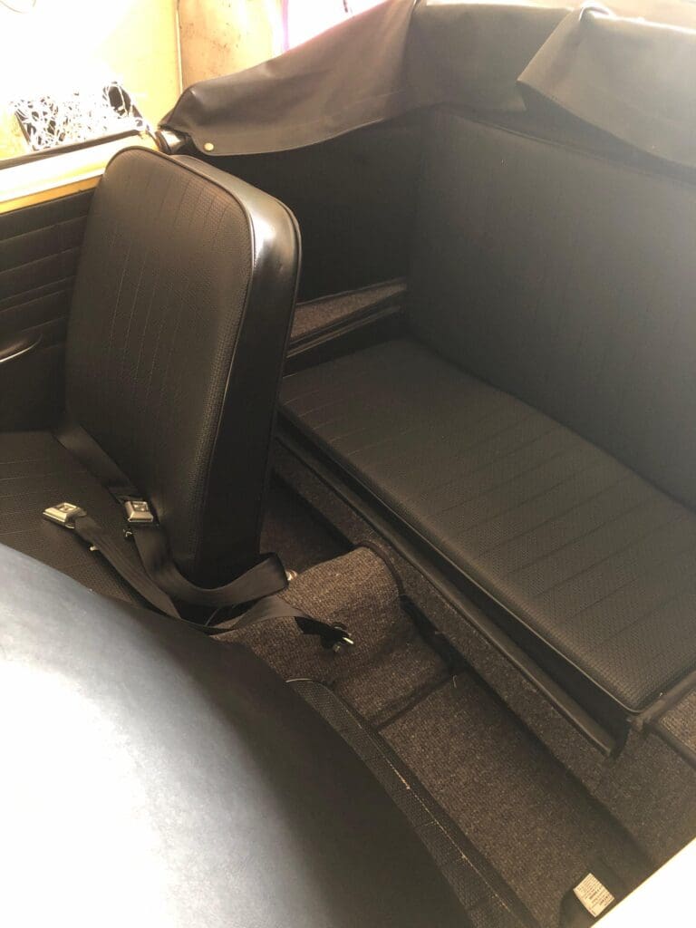 Interior view of a vehicle showing a single front seat and a rear bench seat.
