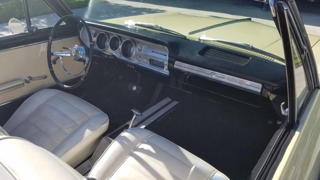 Interior of a vintage car showing the dashboard and front seats.