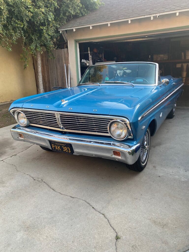 Classic blue vintage convertible parked in a driveway.