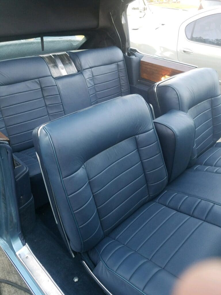 Blue leather car seats with a classic design in a vintage vehicle.