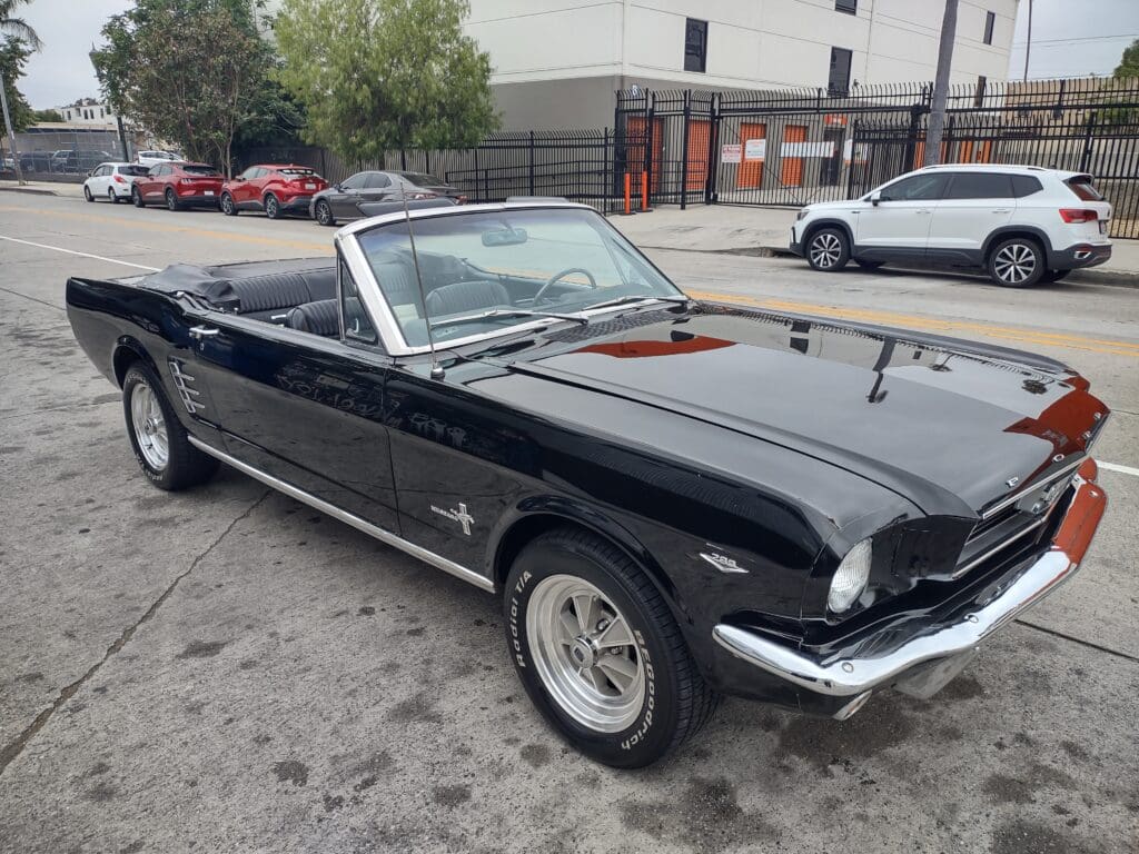 Classic black Ford Mustang convertible parked outdoors.