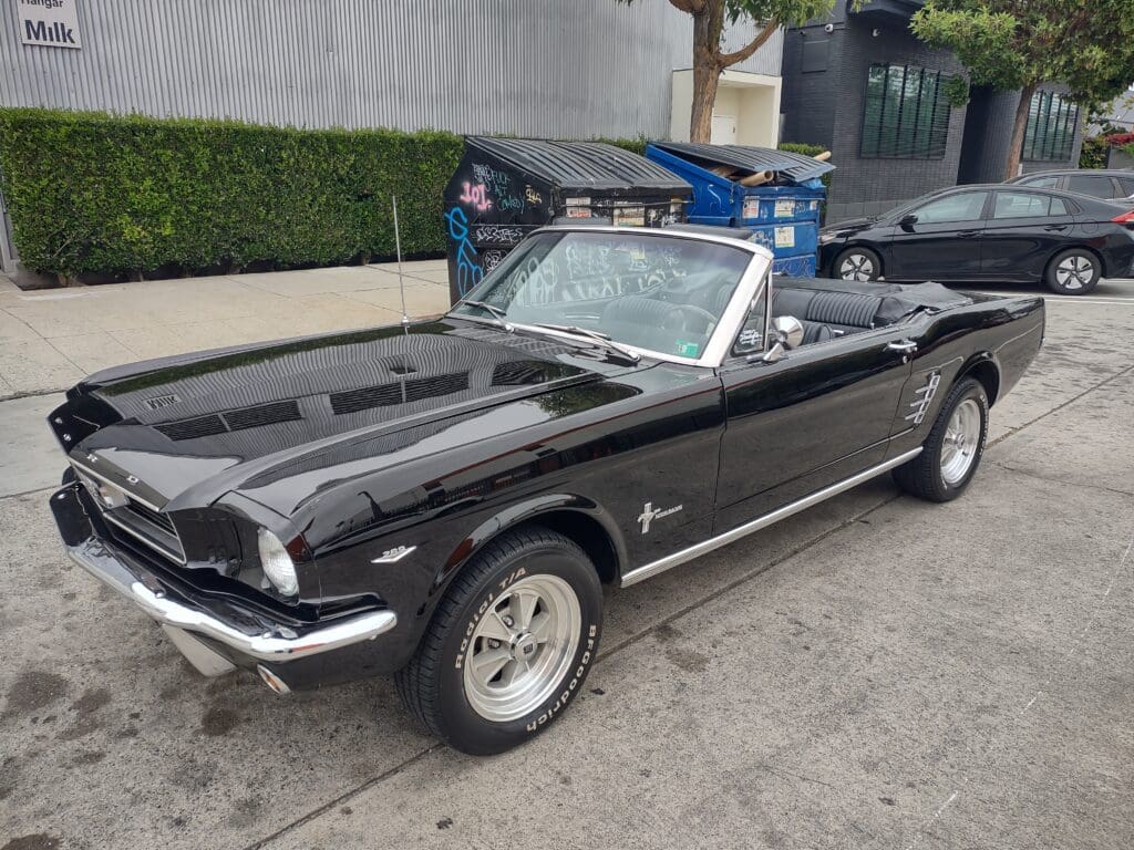 Classic black Ford Mustang convertible parked outdoors.