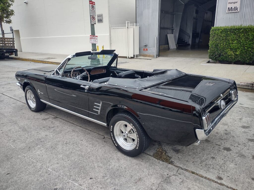 Classic black convertible car parked outdoors.