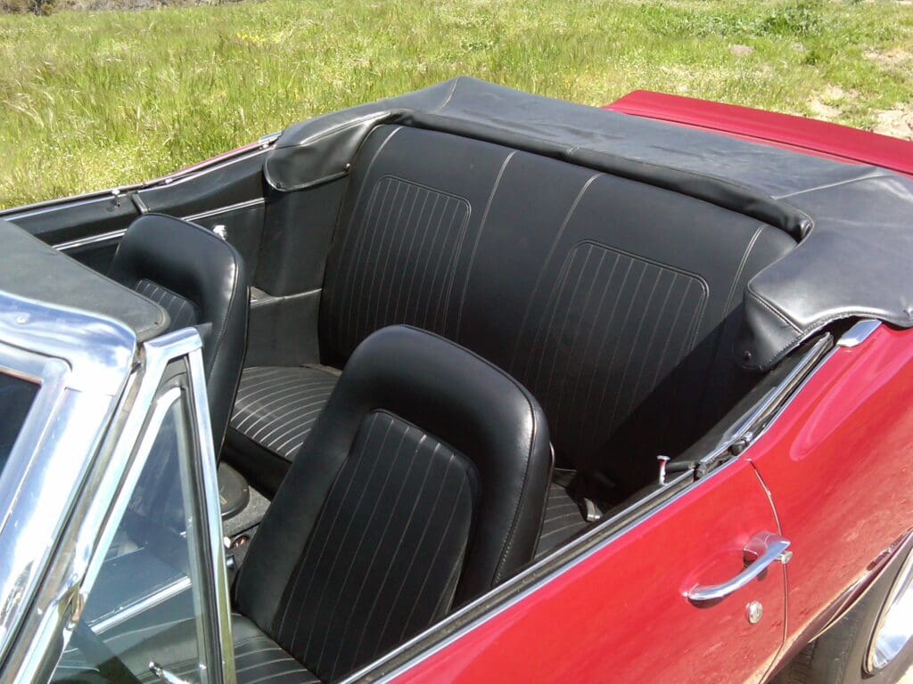 Red convertible car with black leather interior seats.