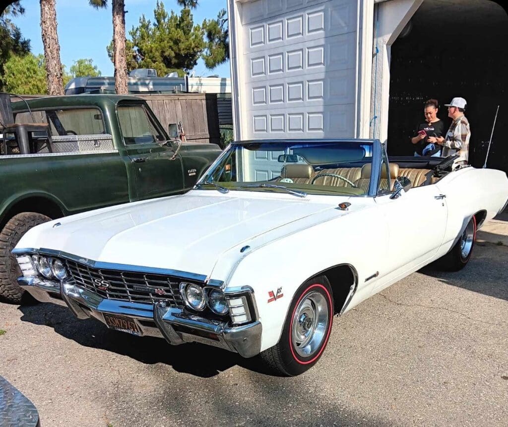 Classic white convertible car parked outdoors on a sunny day.