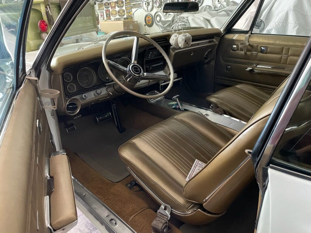 Interior of a vintage car with brown leather seats and classic dashboard.