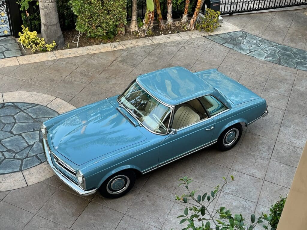 Classic blue vintage car parked on a driveway.