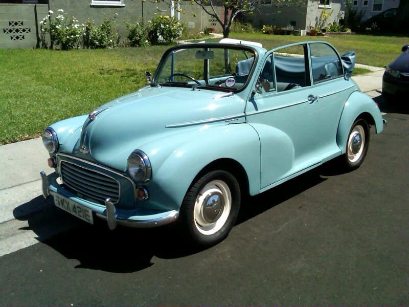 Classic light blue vintage convertible car parked on a driveway.