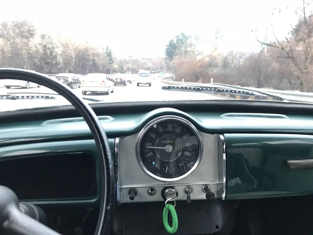 View of a vintage car dashboard and steering wheel.