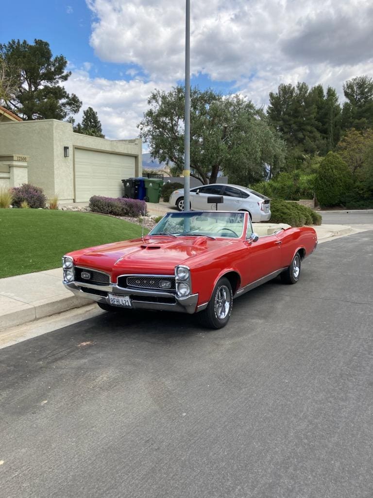 Classic red convertible parked on a suburban street.