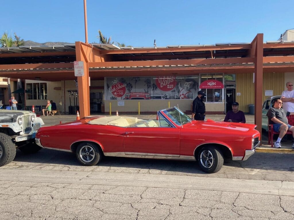 Classic red convertible car parked in front of a retro diner.