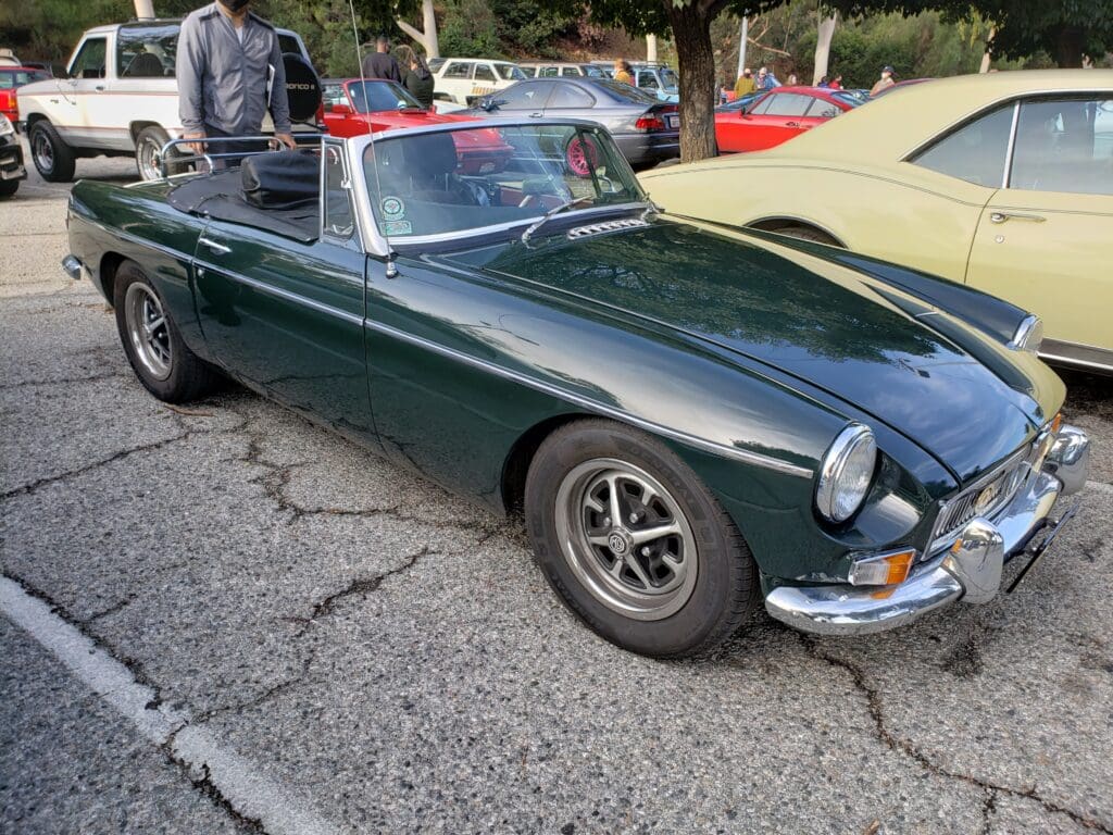Classic dark green convertible sports car parked outdoors.