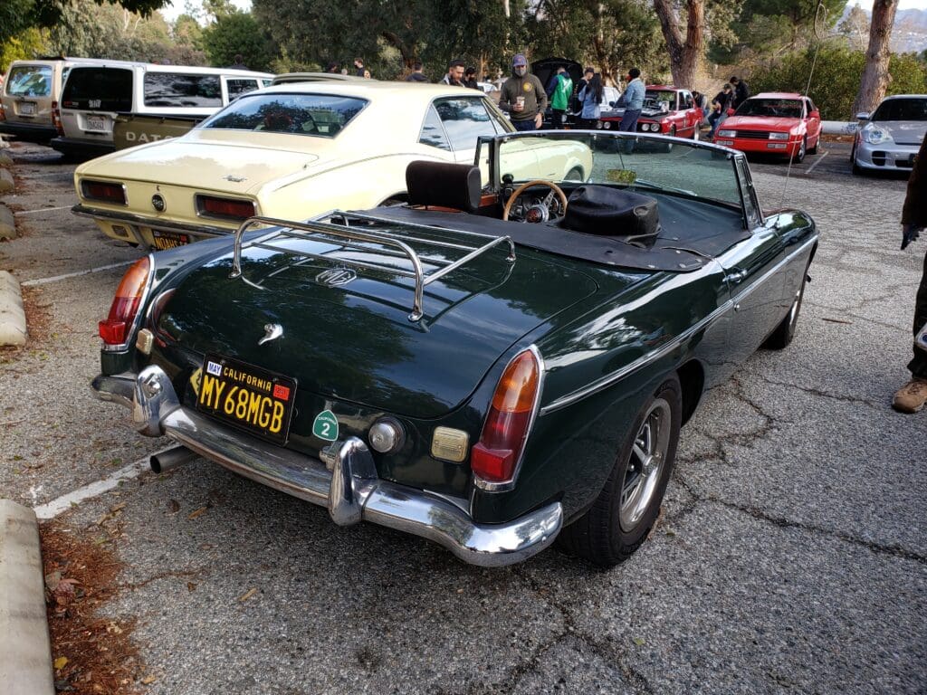 Classic dark green convertible sports car parked outdoors.