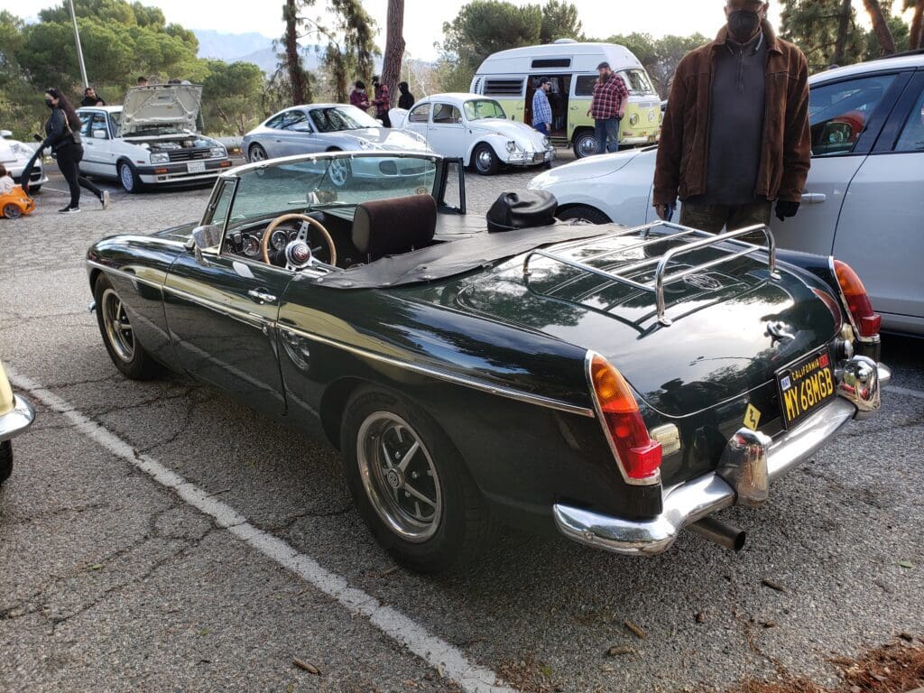 Classic dark green convertible sports car parked outdoors.