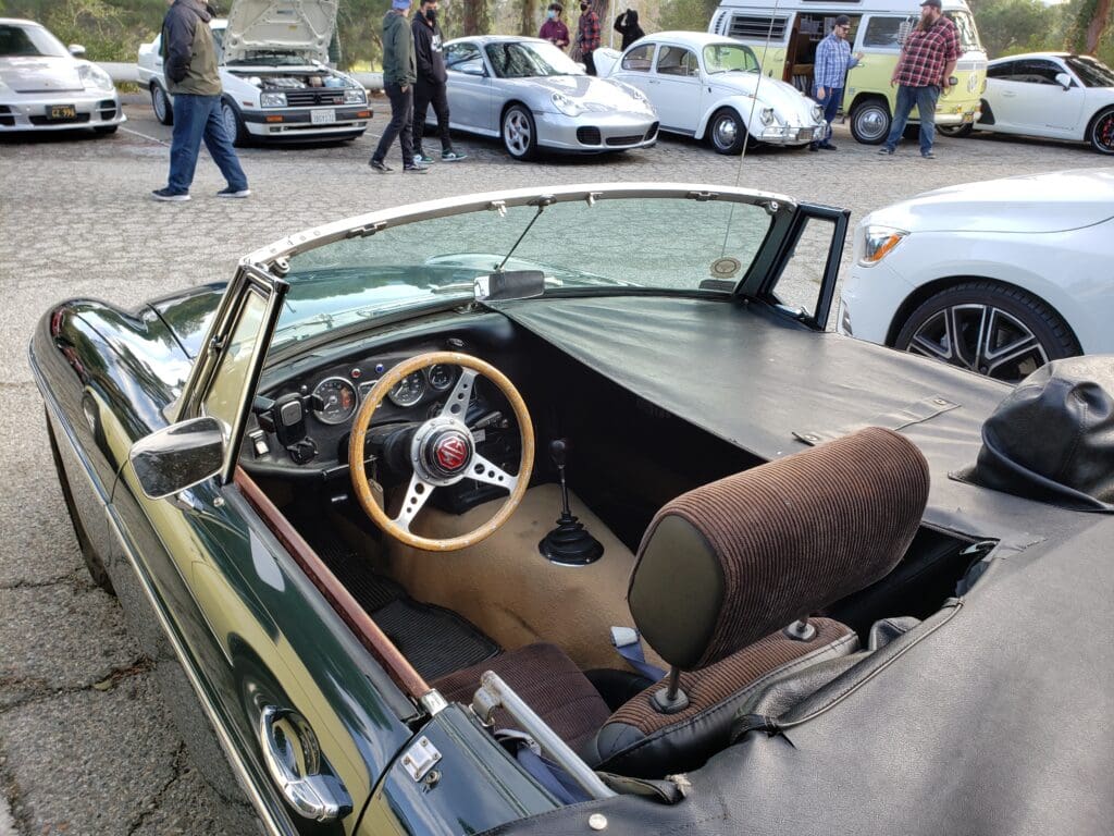 Vintage convertible car with wooden steering wheel and classic dashboard.