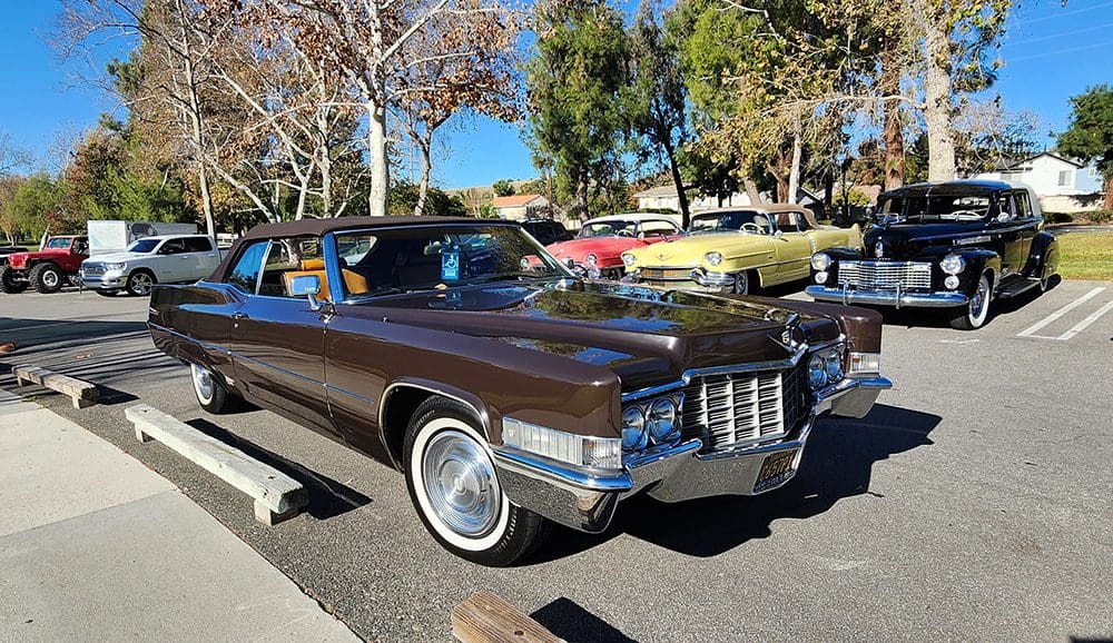 Classic brown vintage car parked outdoors on a sunny day.