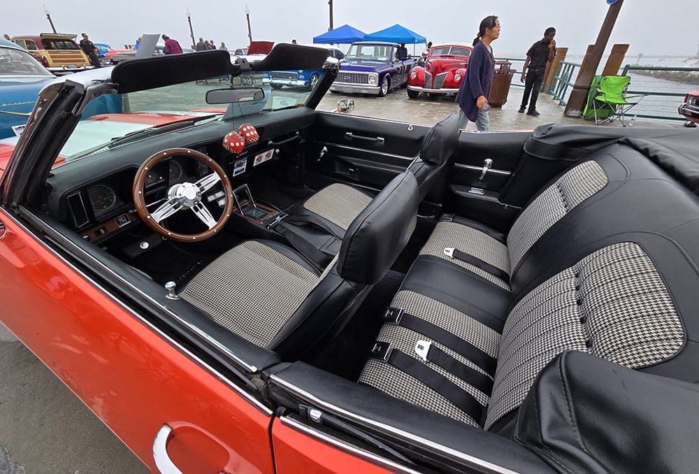 Interior of a classic red convertible car with black and gray seats.