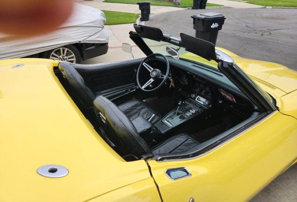 Yellow convertible sports car with black leather interior and steering wheel.