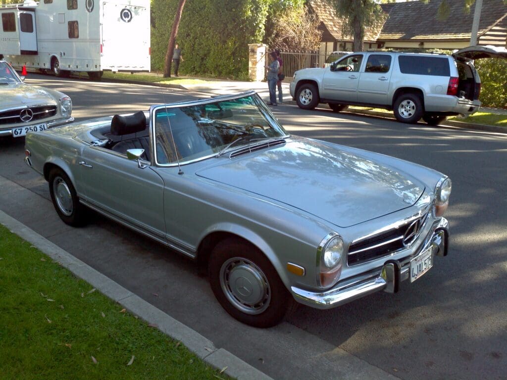 Classic light blue convertible car parked on a street.