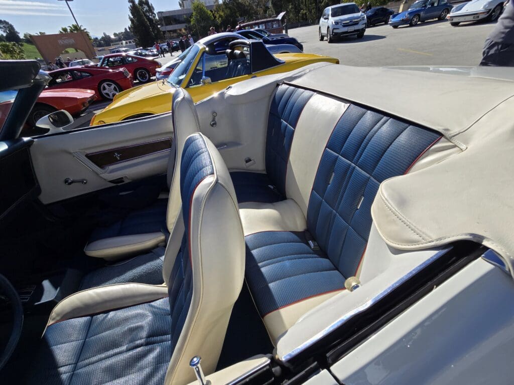 Interior of a classic convertible car with blue and white seats.