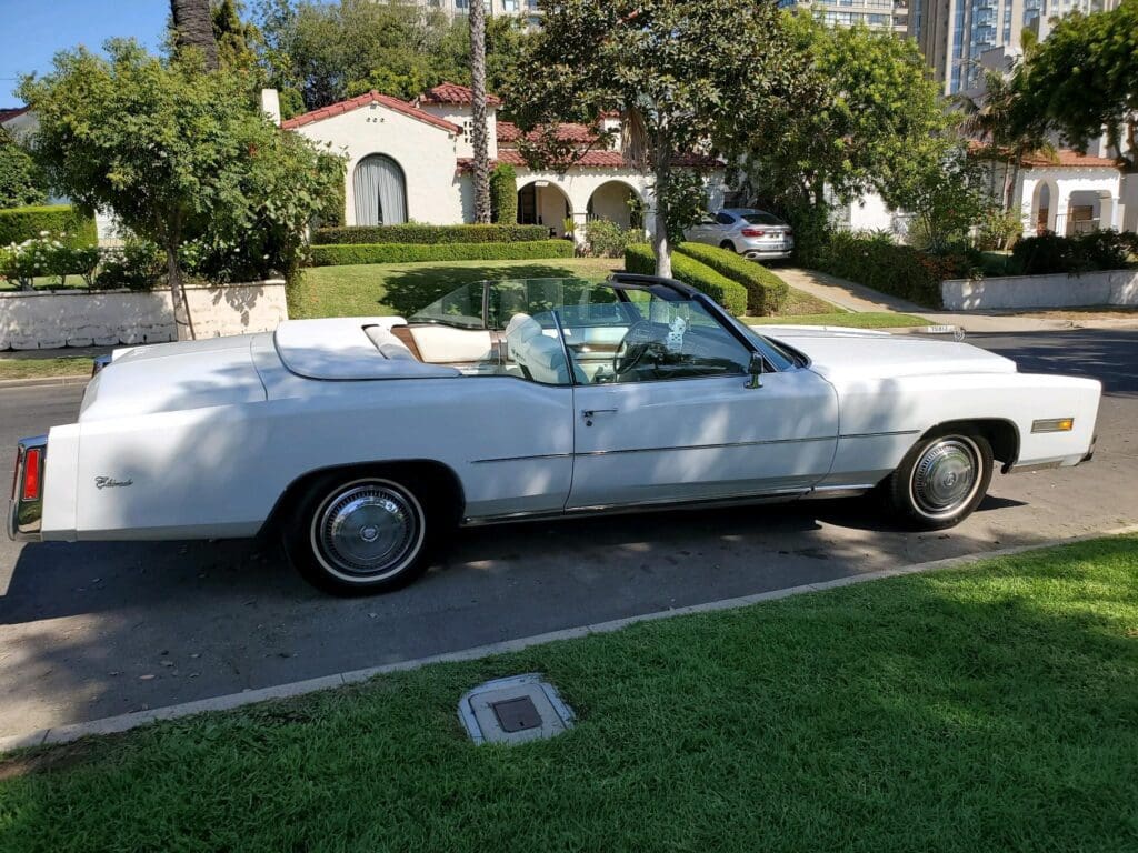 White classic convertible car parked on a residential street.