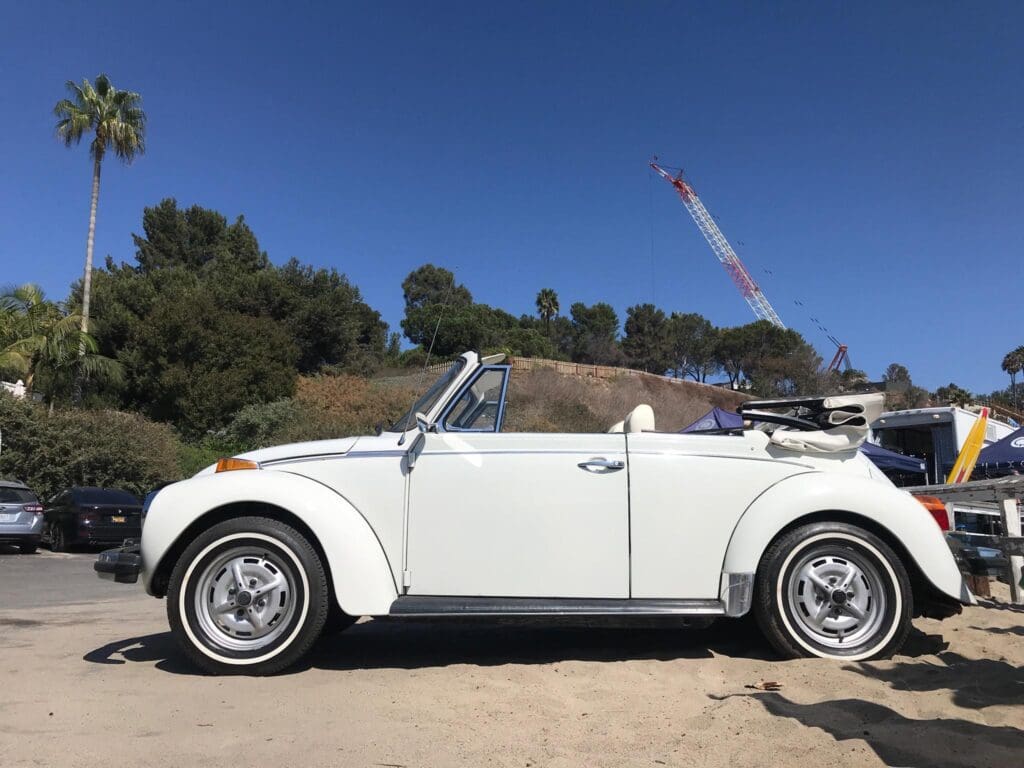 Classic white convertible Volkswagen Beetle parked outdoors.