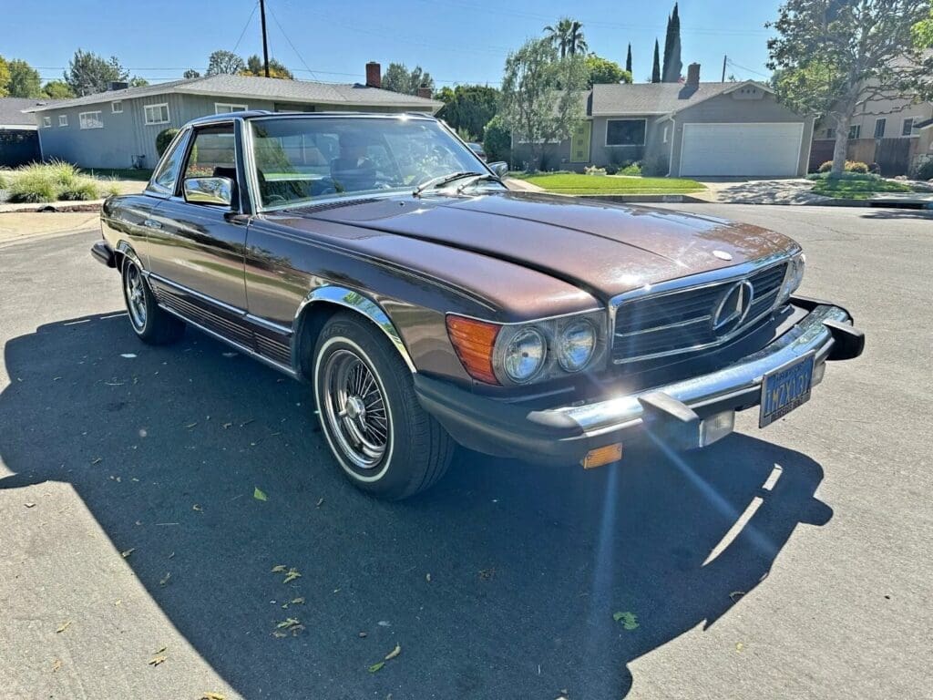 Classic black Mercedes-Benz parked outdoors on a sunny day.