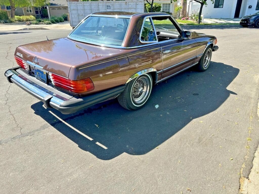 Classic brown Mercedes-Benz convertible parked on a sunny street.