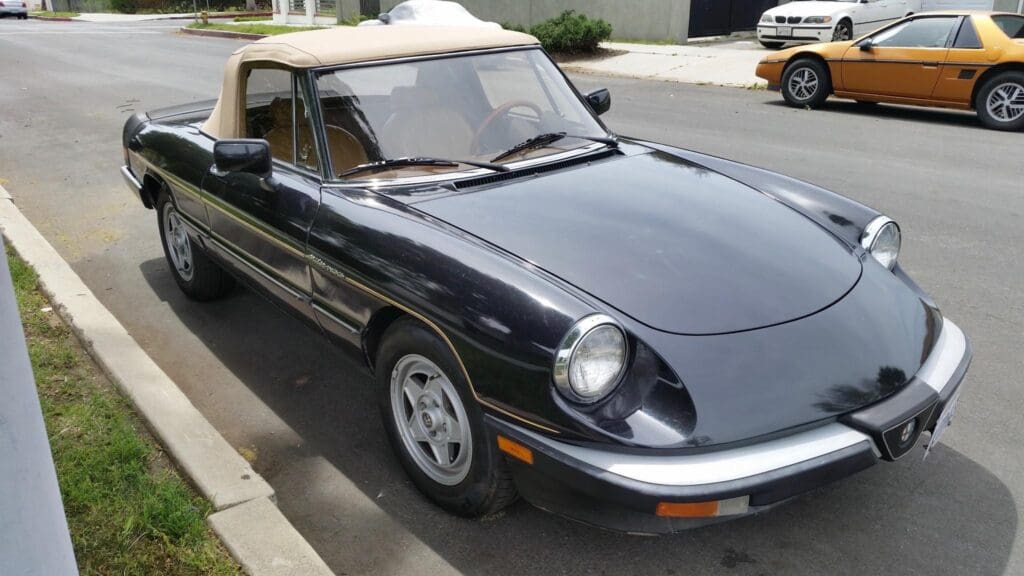 A classic black convertible car parked on the street.