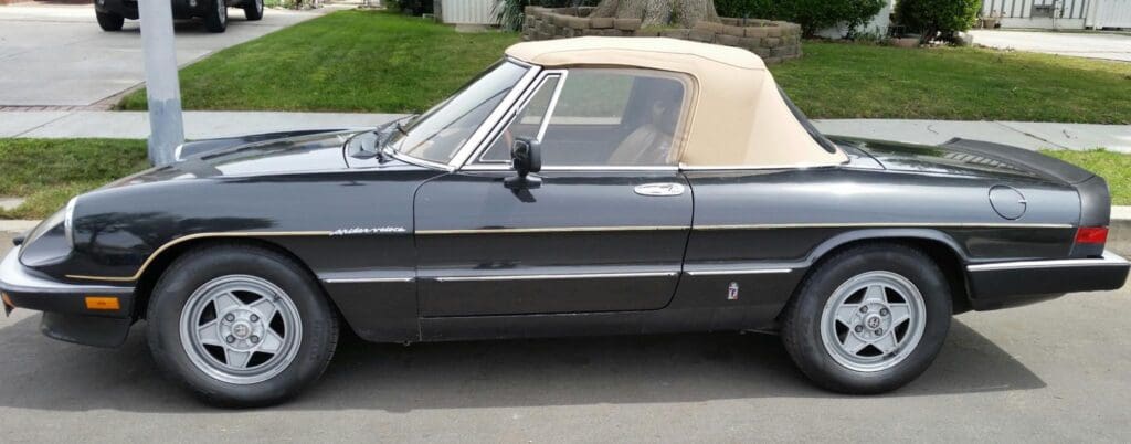 Classic black convertible car with a beige soft top.