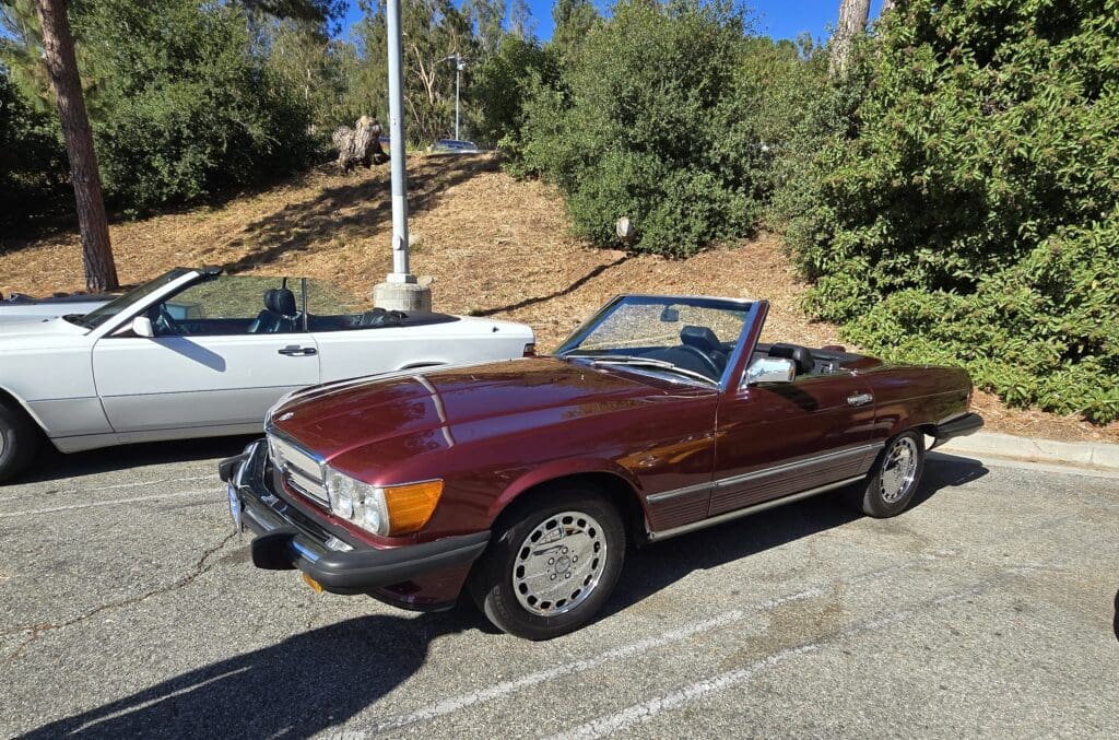 Classic maroon convertible parked outdoors on a sunny day.