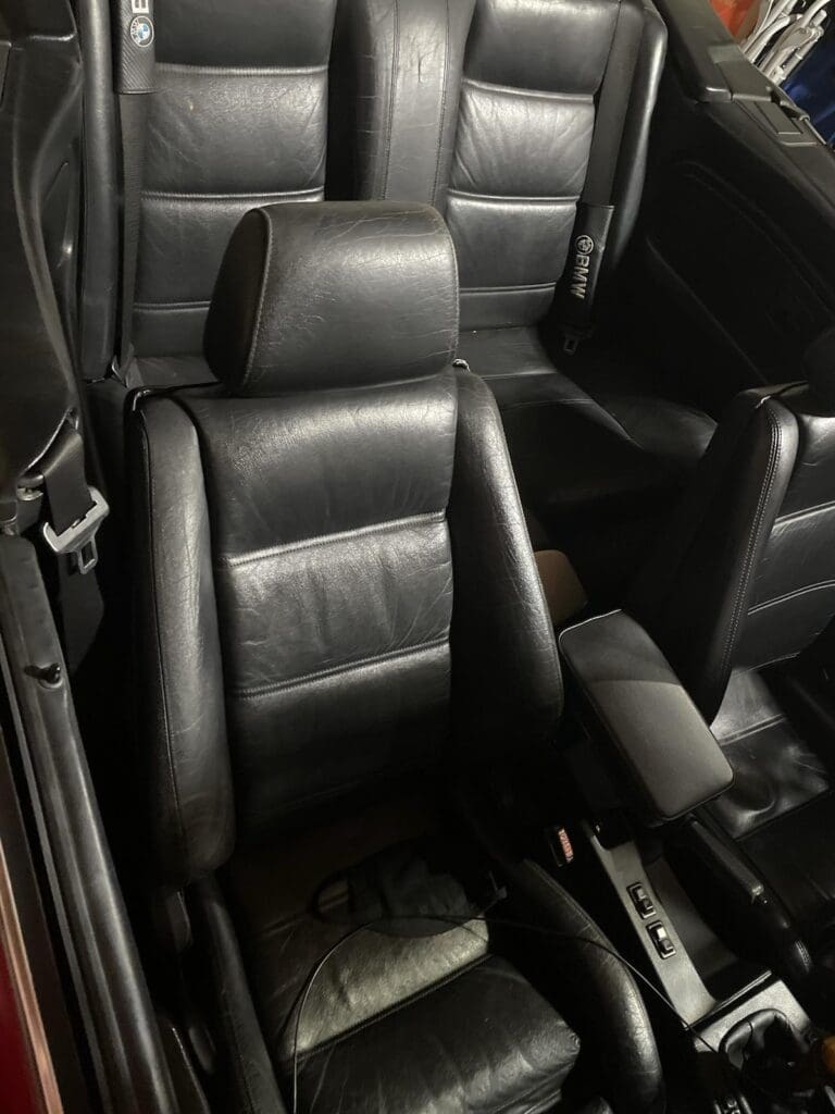 Black leather car seats in a vehicle interior.
