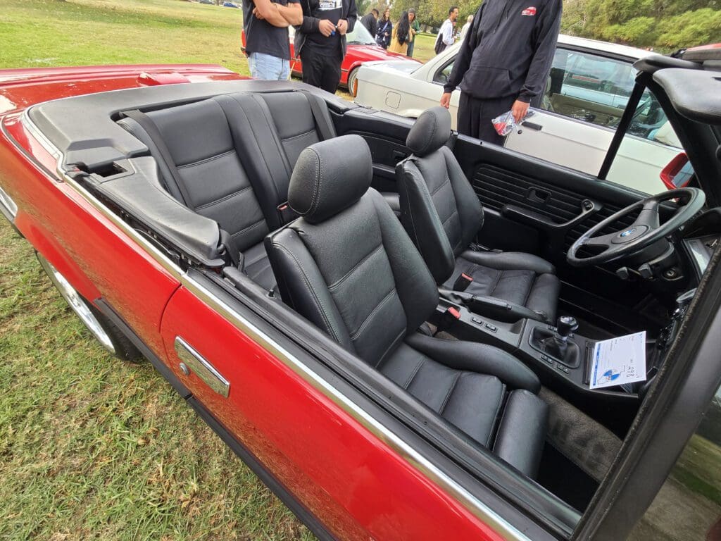Classic red convertible with sleek black leather interior seats.
