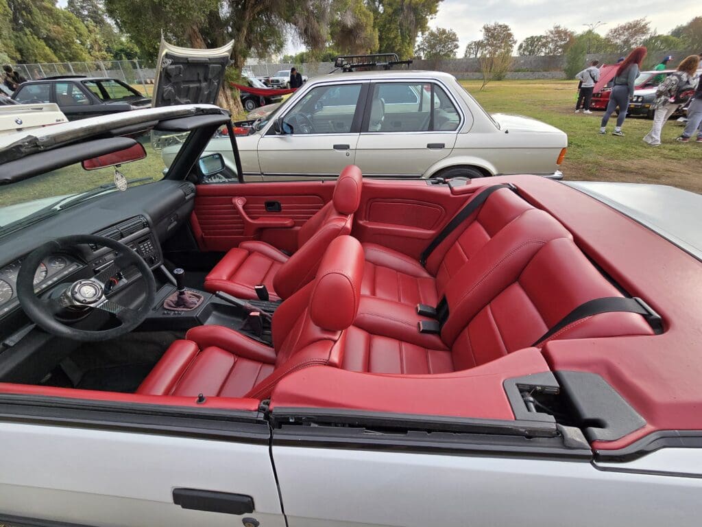 Convertible car with vibrant red leather interior seats.