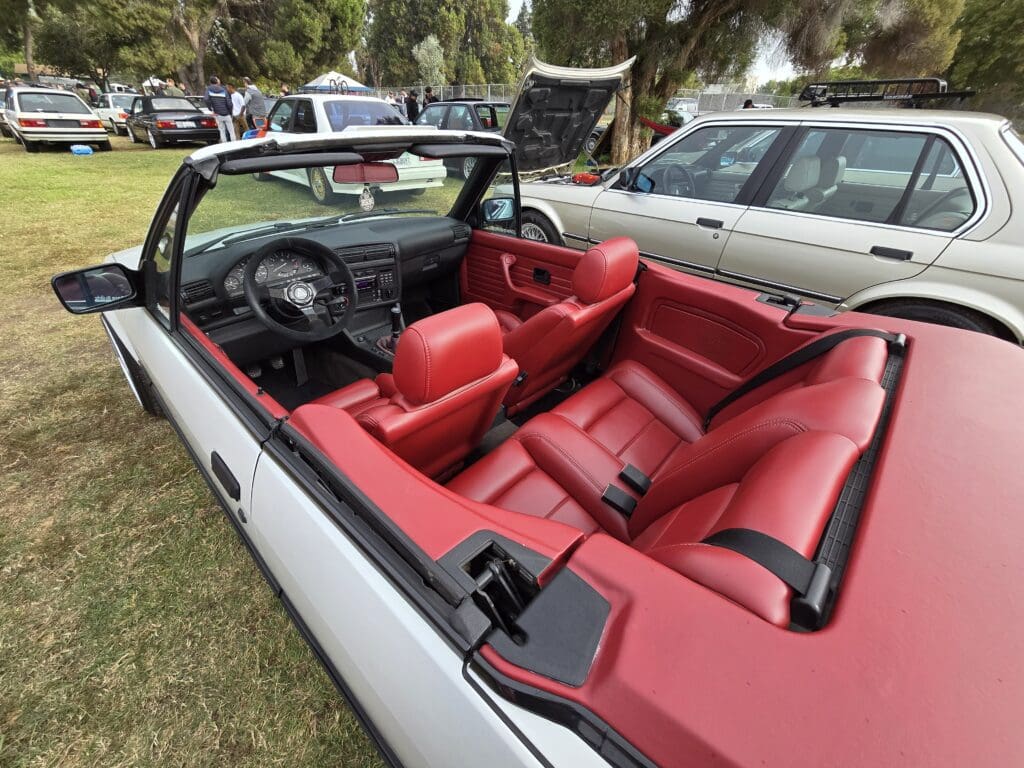 Red leather interior of a classic convertible car with the top down.
