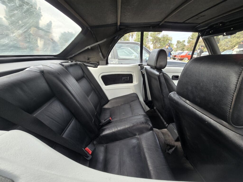 Interior of a car showing black leather back seats and front seats.