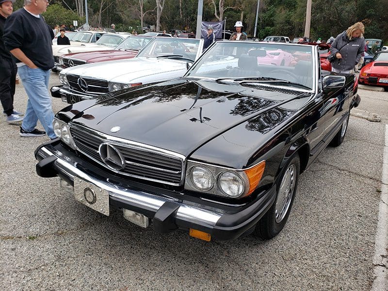Classic black Mercedes convertible parked outdoors.