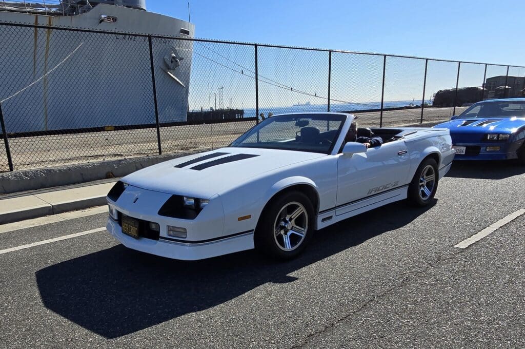 White convertible sports car parked on a sunny street.
