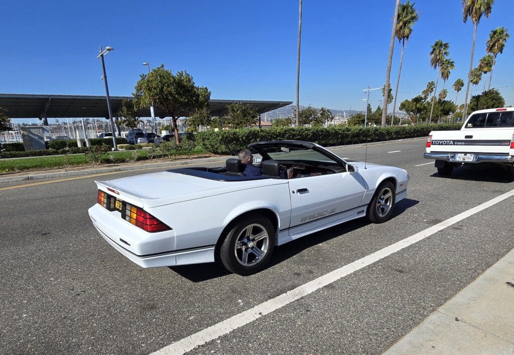 White convertible sports car parked on a sunny street.